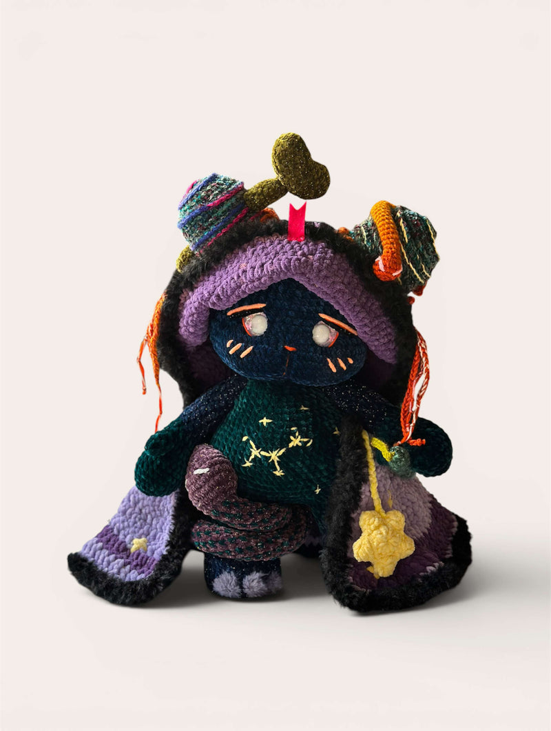 Colorful knitted or crocheted character with a purple hat and scarf on a white background