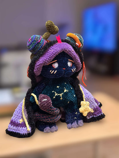 Colorful crochet character with a purple hood and star patterns on a blurred background
